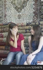 Two young women sitting in a carpet store