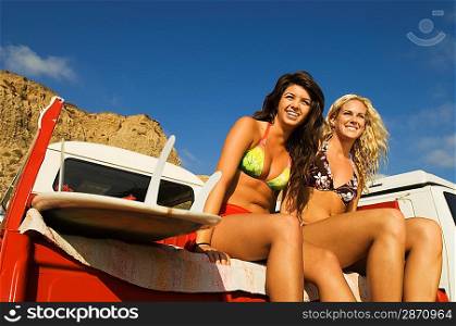 Two Young Women Sitting in Back of Truck