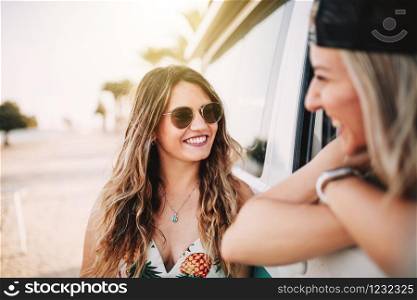 Two young women smiling in a camper van