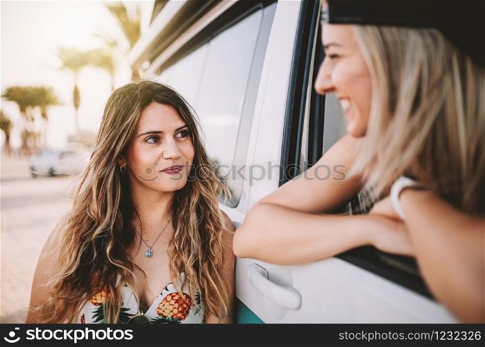 Two young women smiling in a camper van