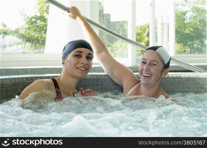 two young women talking in a swimming pool