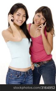 Two young women talking on mobile phones