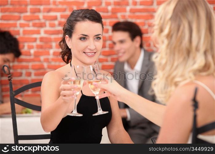 Two young women toasting with champagne
