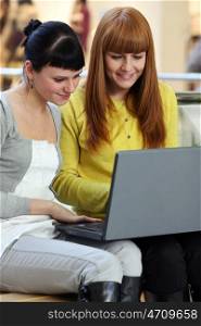 Two young women viewing laptop
