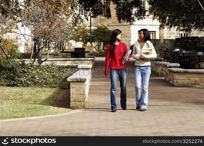 Two young women walking in a college campus