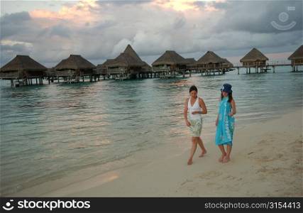 Two young women walking on a beach, Moorea, Tahiti, French Polynesia, South Pacific