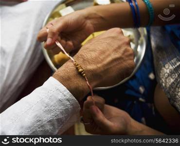 Tying a rakhi on a wrist