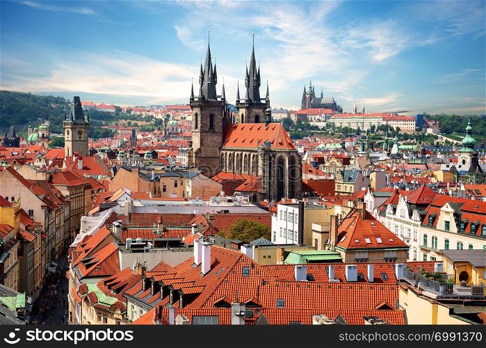 Tynsky and St Vitus cathedral among the red roofs of Prague. View from above