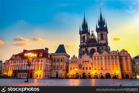 Tynsky Temple on illuminated Old Town square in Prague at sunrise