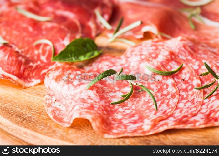 Types of ham and salami with herbs close up. Types of ham