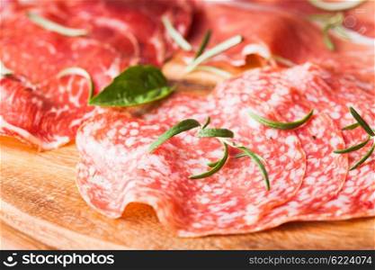 Types of ham and salami with herbs close up. Types of ham