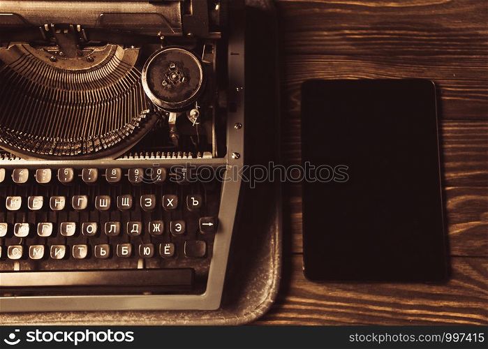 typewriter and a modern gadget. new technology.. typewriter and a modern gadget. new technology