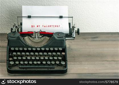 typewriter with white paper page on wooden table. sample text Be My Valentine!