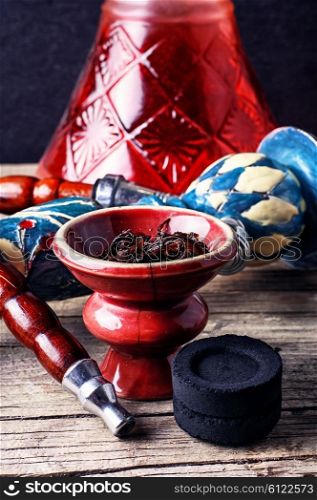 Typical details of smoking hookah on a wooden background. Preparation of hookah smoking
