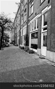 Typical Dutch brick houses in Holland. Street View with bikes parked in the historical center of Amsterdam in the Netherlands. Black and white picture