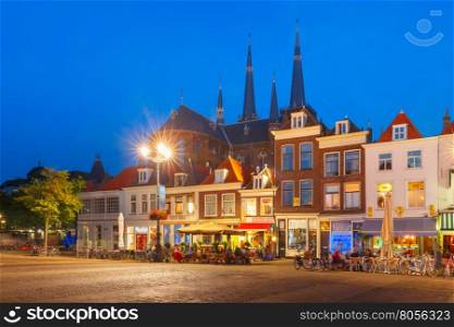 Typical Dutch houses on the Markt square in the center of the old city at night, and Maria van Jessekerk on the background, Delft, Holland, Netherlands