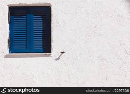 Typical Greek architecture details concept. Blue window shutters on house in Greece.. Greek blue window shutters