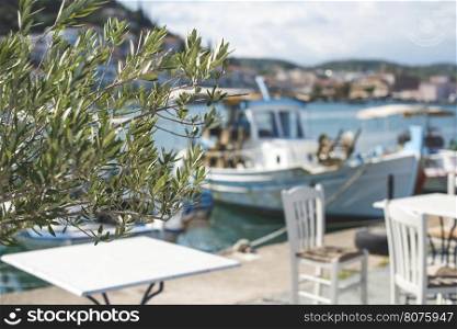 Typical greek restaurant and fish boat on the background. Greece, Gythio
