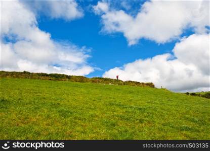 Typical green Irish country side with blue sky and man alone