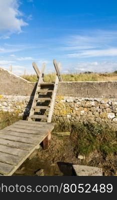 Typical ladder stile, over wall, with bridge over ditch. Aberthaw beach, South Wales, United Kingdom, Europe.