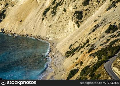 typical landscape of the island of Kefalonia with its mountains plummeting over its beaches and leaving rocks that the waves of the sea turns first into pebbles and then into powder that give the turquoise tint to the sea next to the coasts.
