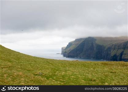 Typical landscape on the Faroe Islands, with green grass and cliff on the northern edge of Eysturoy