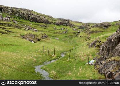 Typical landscape on the Faroe Islands, with green grass and rocks