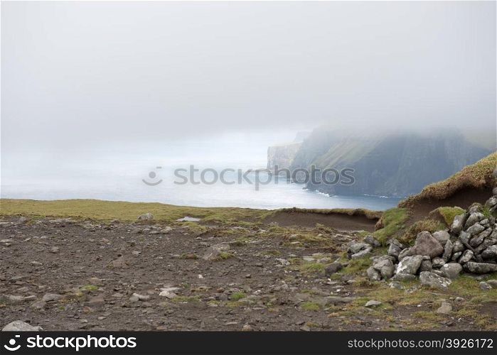 Typical landscape on the Faroe Islands, with green grass and rocks at the northern edge of eysturoy