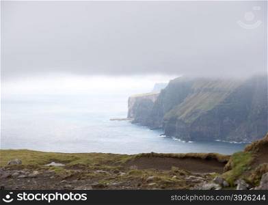 Typical landscape on the Faroe Islands, with green grass and rocks at the northern edge of eysturoy