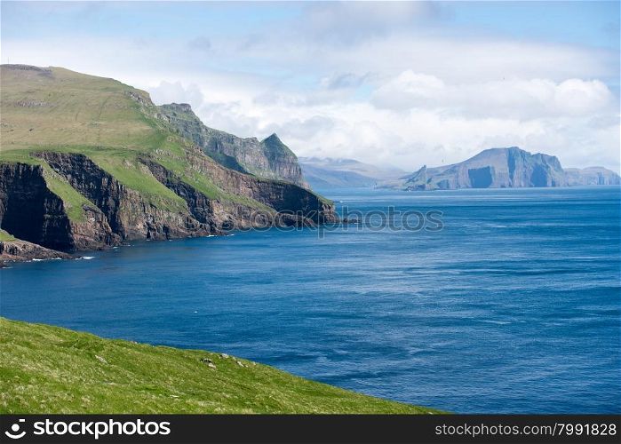 Typical landscape on the Faroe Islands, with green grass, water and rocks