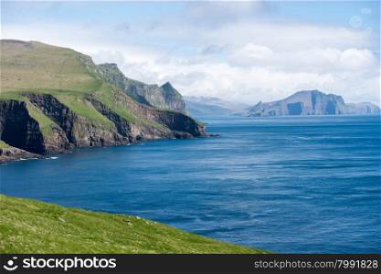 Typical landscape on the Faroe Islands, with green grass, water and rocks