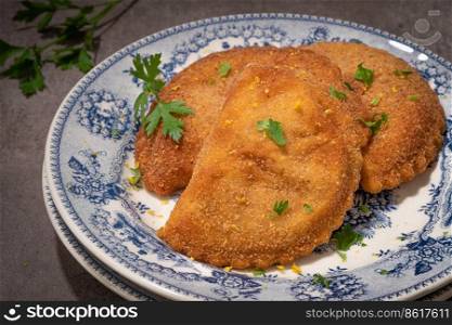 Typical Portuguese appetizer "rissois" or rissoles, meat or shrimp breaded turnovers. Parsley on the background