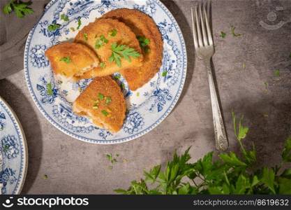 Typical Portuguese appetizer "rissois" or rissoles, meat or shrimp breaded turnovers. Parsley on the background
