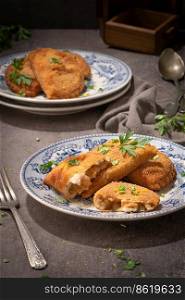 Typical Portuguese appetizer  rissois  or rissoles, meat or shrimp breaded turnovers. Parsley on the background