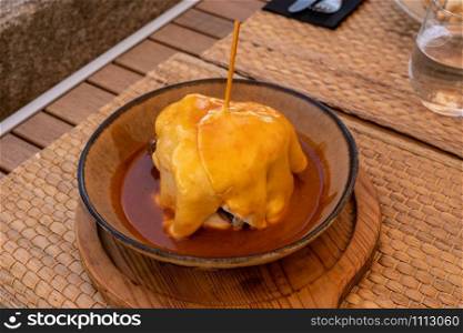 Typical portuguese sandwich like croque monsieur called Francesinha with cheese and steak. Typical portuguese sandwich called Francesinha with cheese and steak