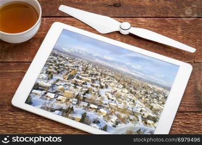 typical residential neighborhood along Front Range of Rocky Mountains in Colorado, winter scenery with fresh snow - reviewing an earial image on a digital tablet