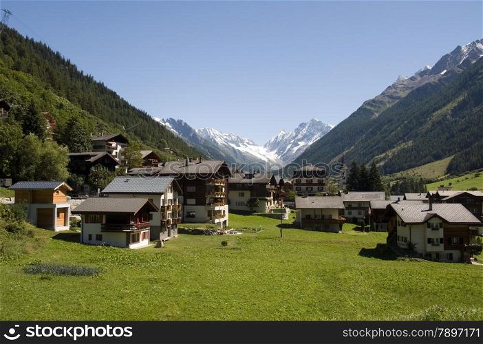 typical Switsch houses with the mountains and snow as a background