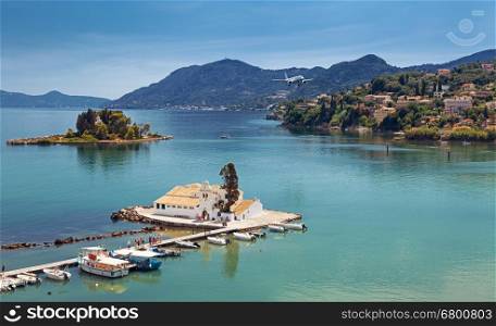 Typical view of Vlacherna Monastery and Mouse island with airplane landing, Corfu, Greece.