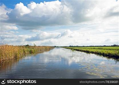 Typical wide dutch landscape with meadows, water and cloudscapes