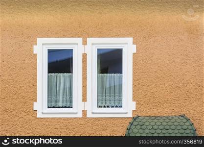 Typical windows of a house in a small town in Austria. Home in the Austrian city of Gmunden in a rainy day. Retro style