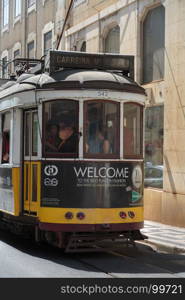 Typical Yellow Vintage Tram in Narrow Street of Lisbon, Portugal