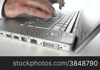 Typing finges on a silver laptop keyboard