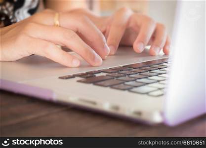 Typing on keyboard laptop at work table, stock photo