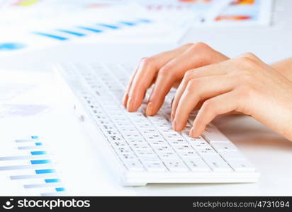 Typing work. Close up of female hands typing on keyboard