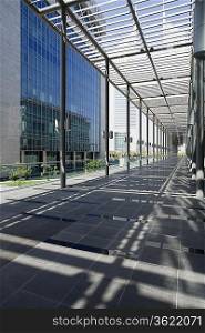 UAE, Dubai, architectural detail of a long outdoor hallway at the Dubai International Financial Centre