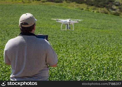 UAV Drone Pilot Flying and Gathering Data Over Country Farm Land.