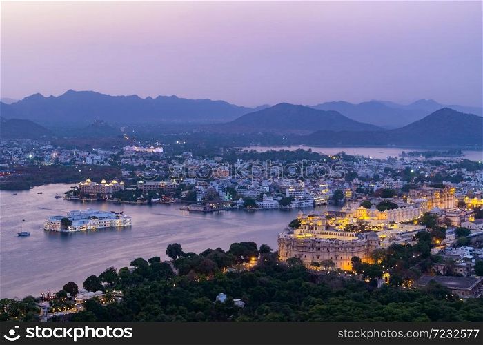 Udaipur city at lake Pichola in the evening, Rajasthan, India. View from the mountain viewpoint see the whole city reflected on the lake.. Udaipur city at lake Pichola in the evening, Rajasthan, India.