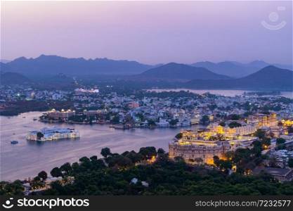 Udaipur city at lake Pichola in the evening, Rajasthan, India. View from the mountain viewpoint see the whole city reflected on the lake.. Udaipur city at lake Pichola in the evening, Rajasthan, India.