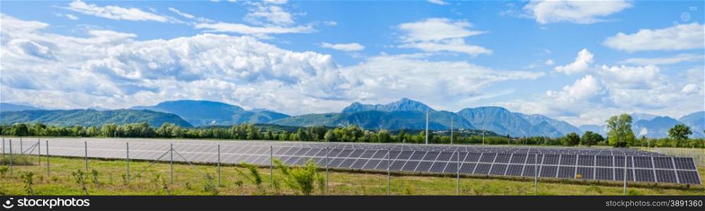 Udine,Italy - 24 May 2015 : Landscape with solar power station and the Italian Alps in the background