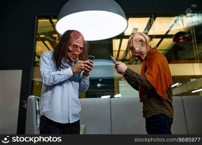 Ugly zombie people using digital device in office. Social media network, gadget addiction concept. Ugly zombie people using digital device in office